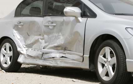 Image of a car showing some side panel collision damage